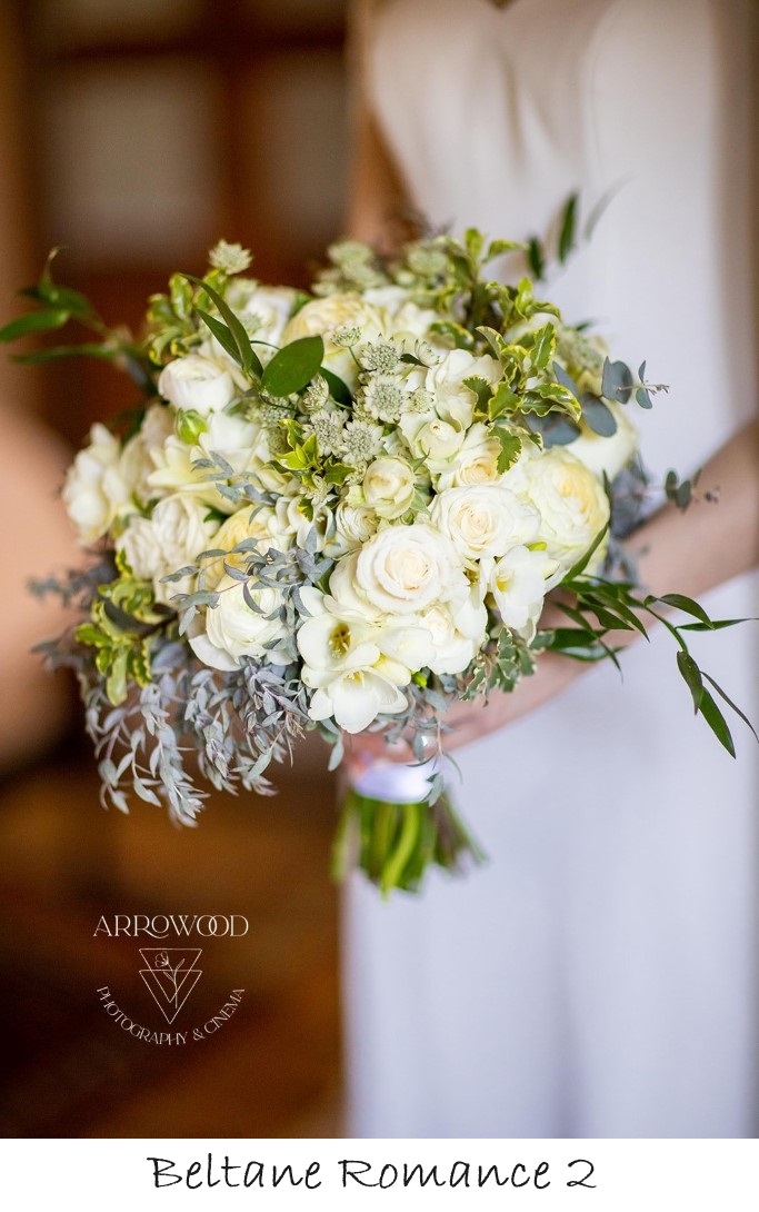 bride holding bouqet with white roses